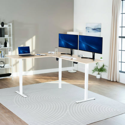 Modern home office with a adjustable l-shaped desk, laptop, and two monitors.