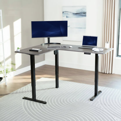 L-shaped desk with computer setup in a bright room
