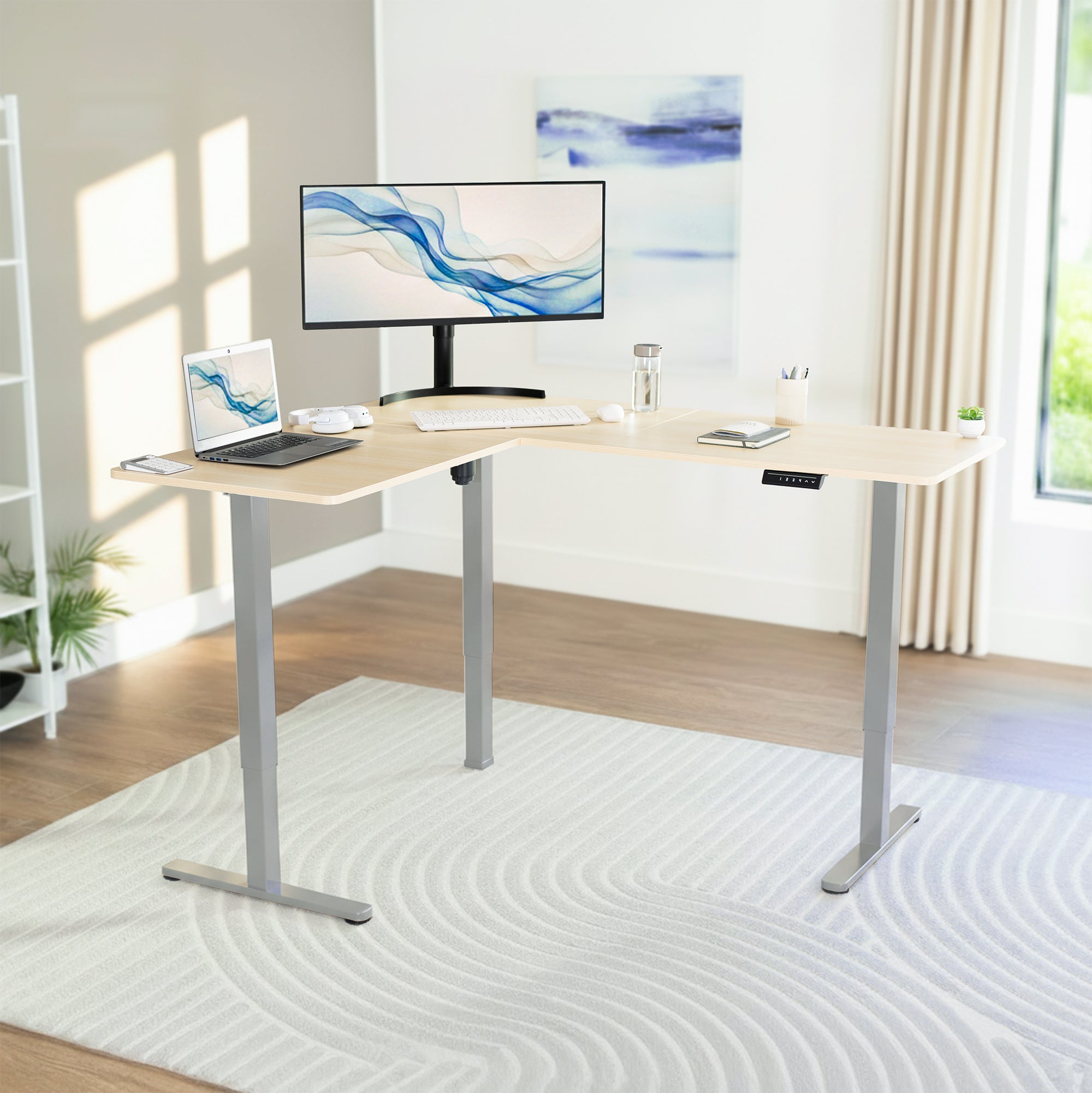 L-shaped desk with computer setup in a bright room