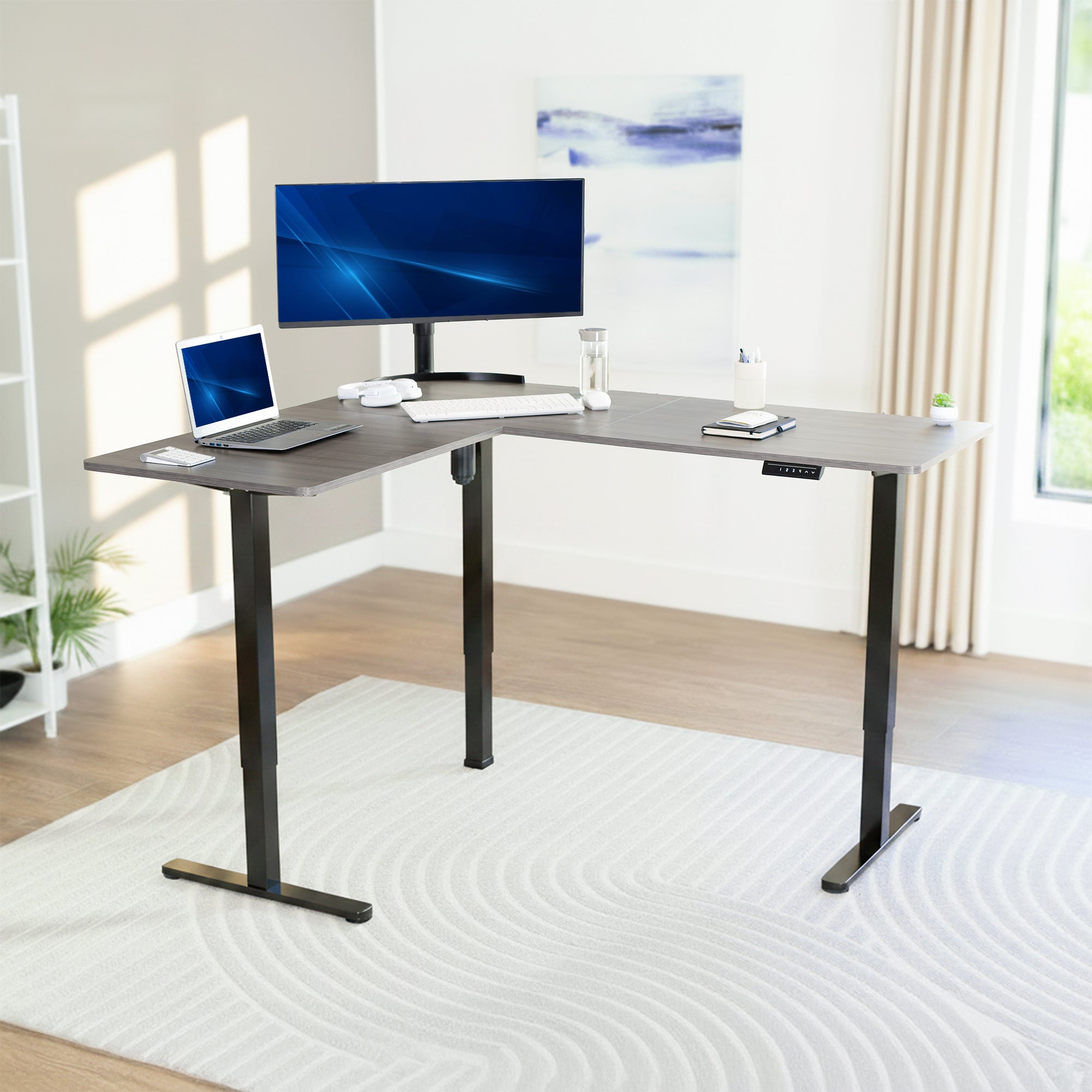 L-shaped desk with computer setup in a bright room