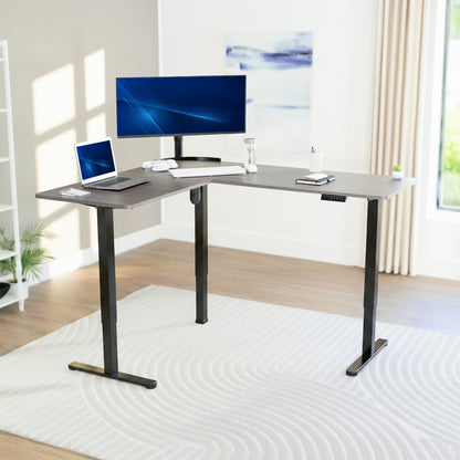 L-shaped desk with computer setup in a bright room