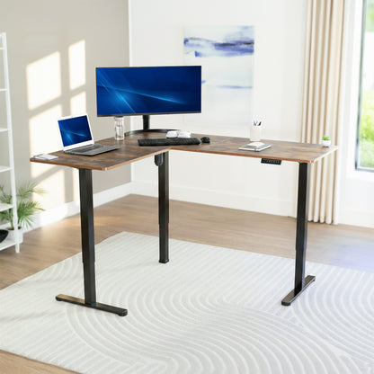L-shaped desk with computer setup in a bright room