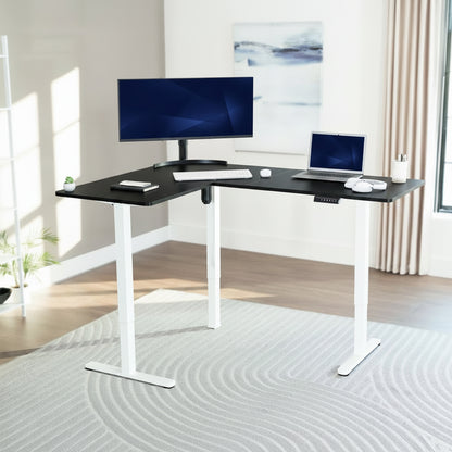L-shaped desk with computer setup in a bright room