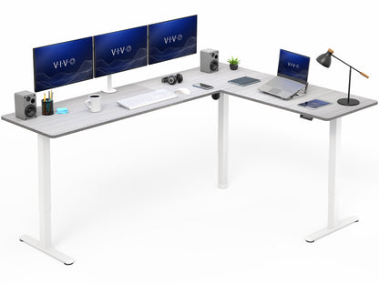 L-shaped desk with computer setup including monitors, keyboard, and laptop on a white background