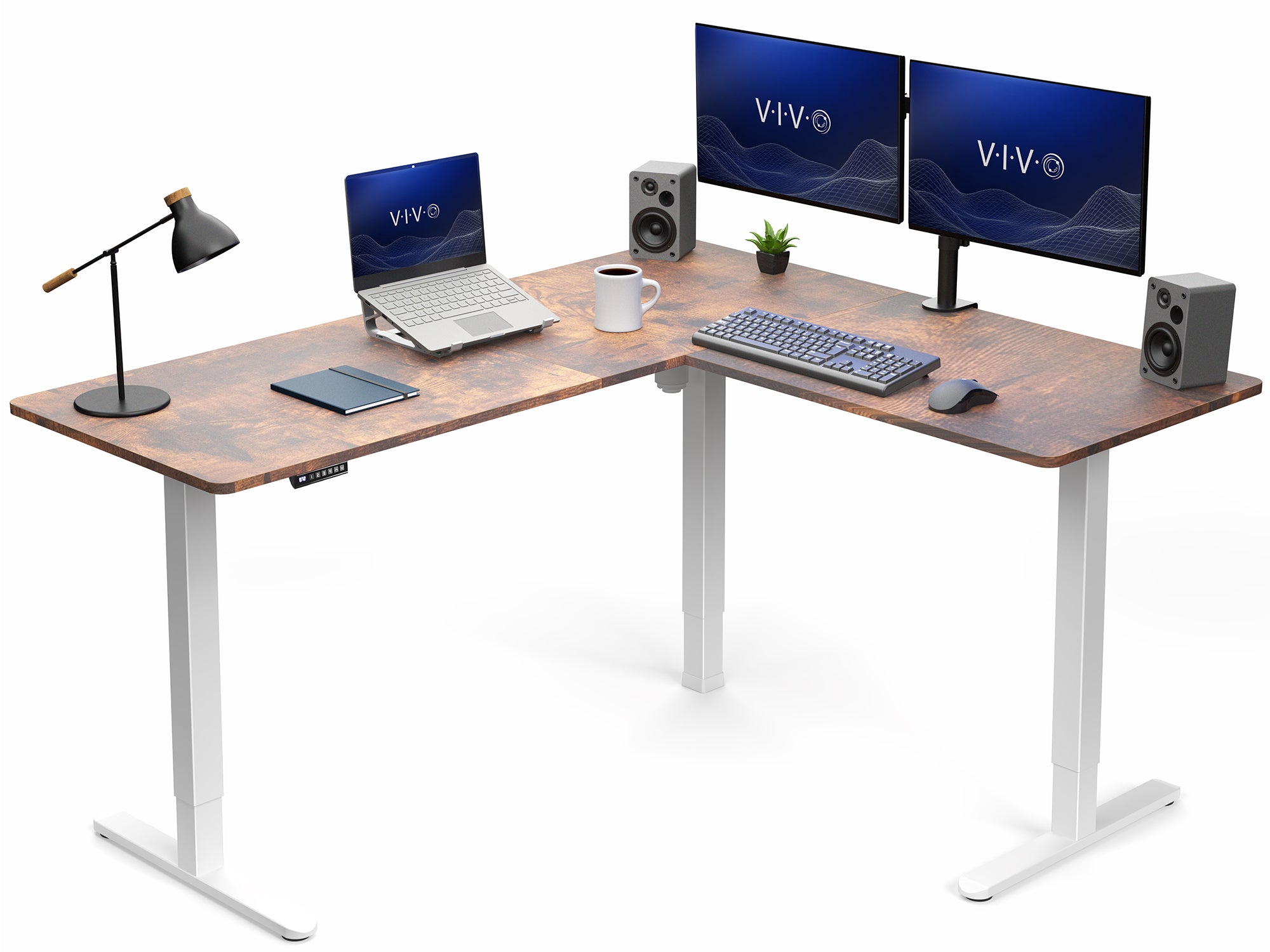 Wooden L-shaped desk with computer setup including two monitors, laptop, keyboard, and speakers on a white background.