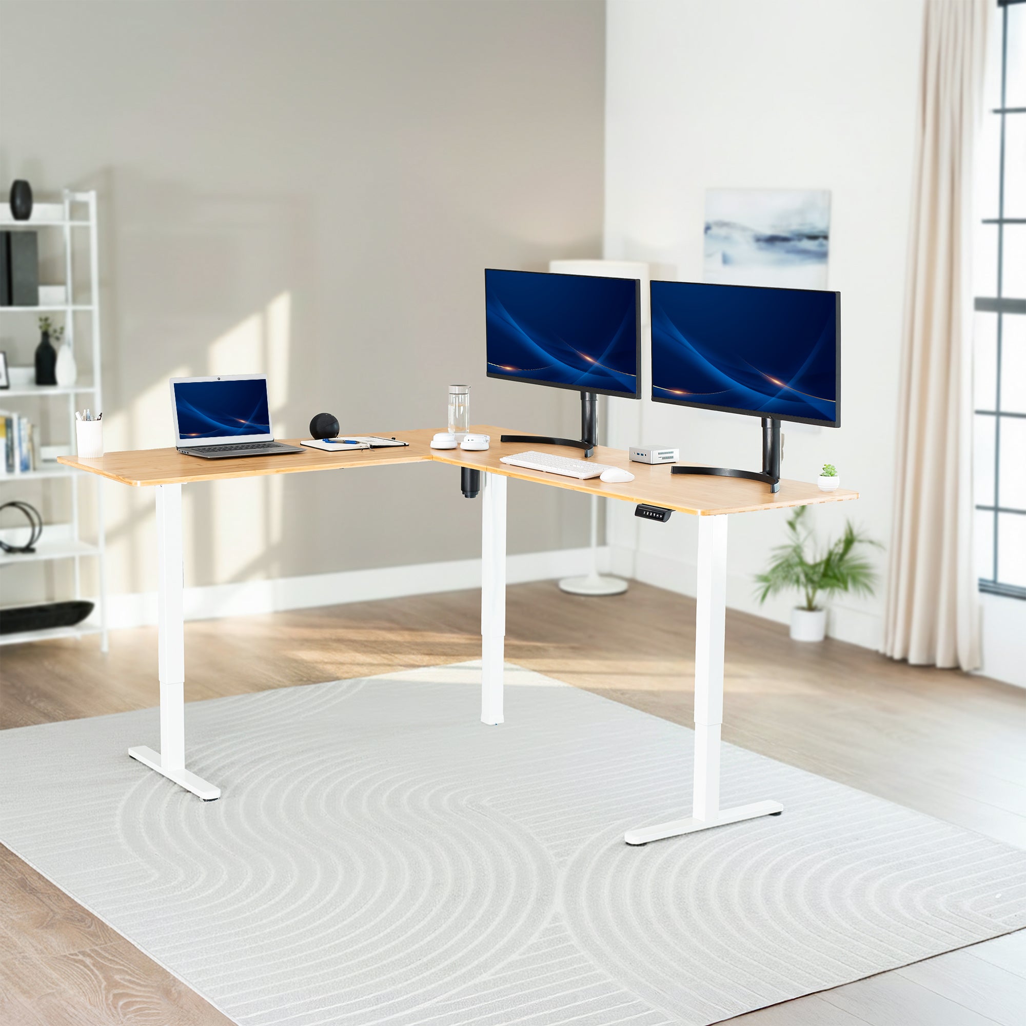 Modern home office with a adjustable l-shaped standing desk, laptop, and two monitors.