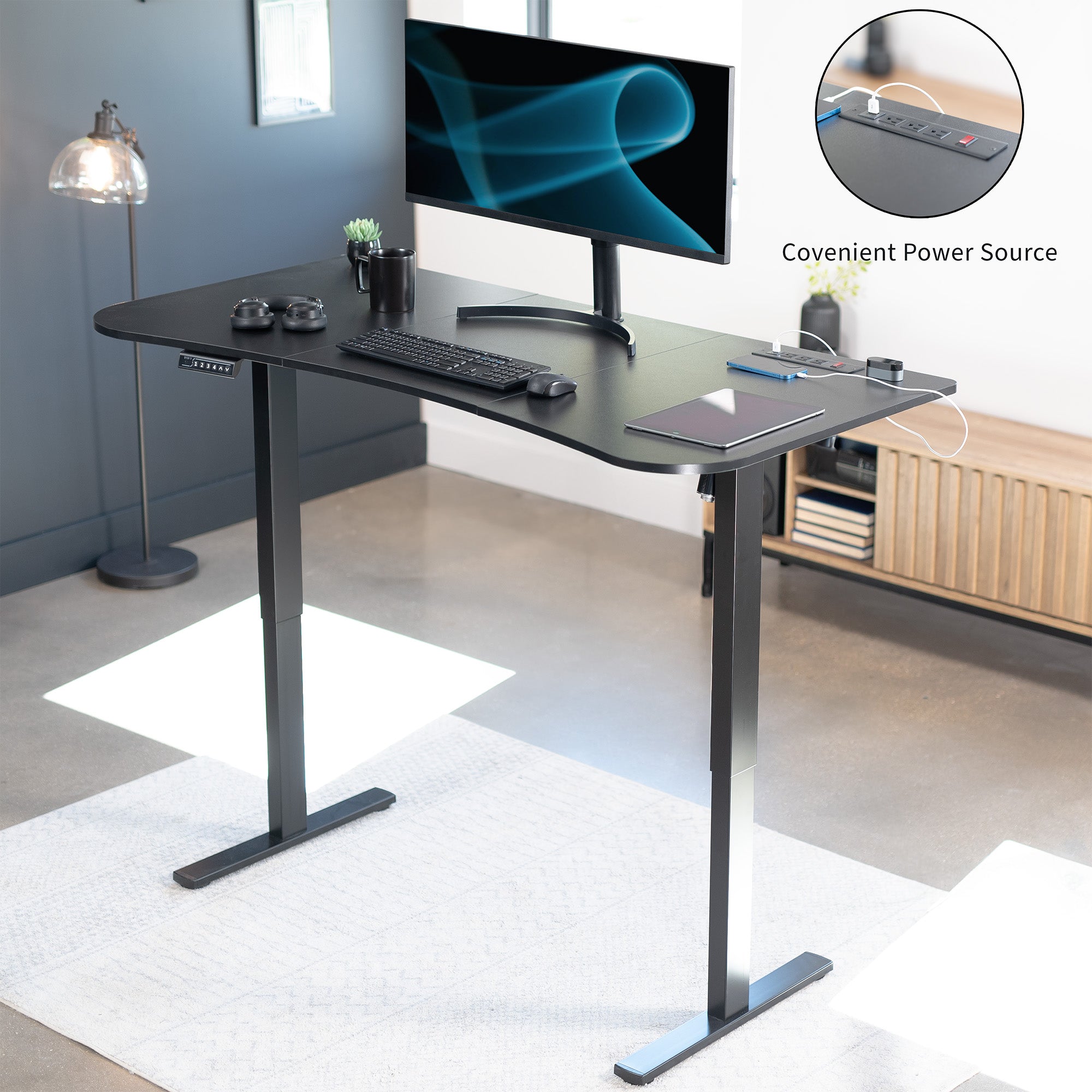 Sit to stand height adjustable electric desk with push button memory controller. Features a built-in power strip.