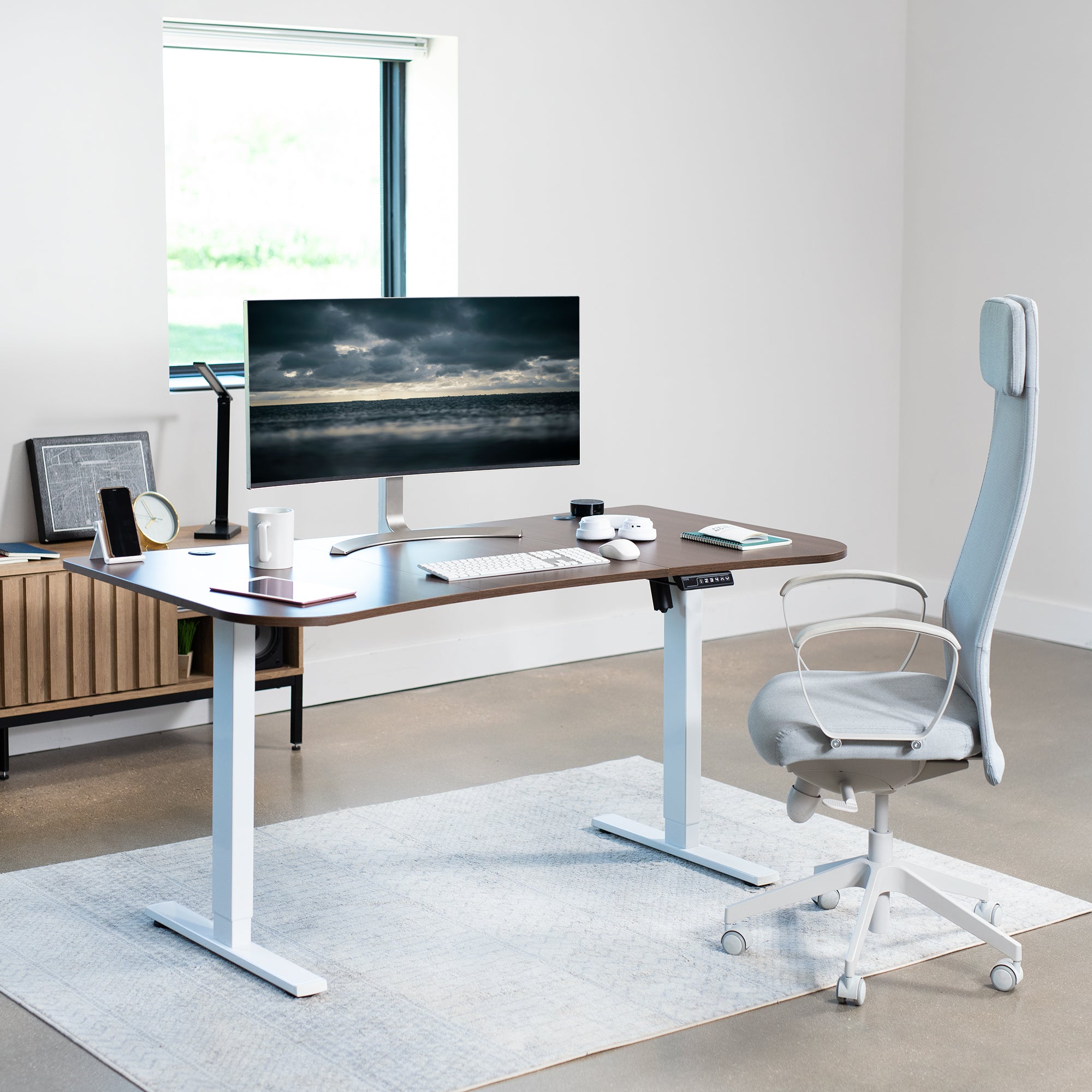 Sit to stand height adjustable electric desk with push button memory controller for ergonomic office workstation.