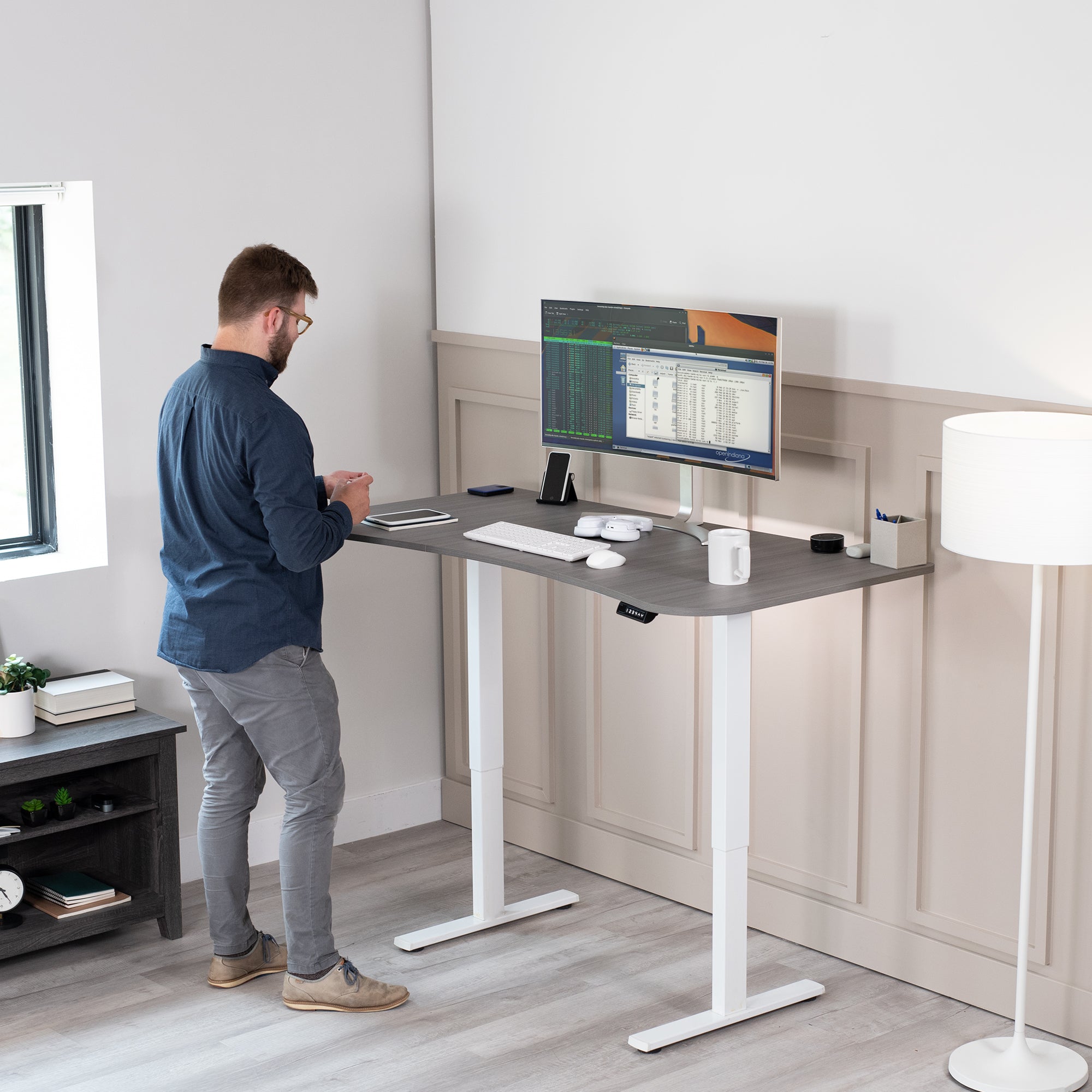 Sit to stand height adjustable electric desk with push button memory controller for ergonomic office workstation.