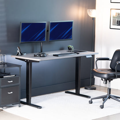 Modern office setup with a standing desk, computer monitors, and chair.