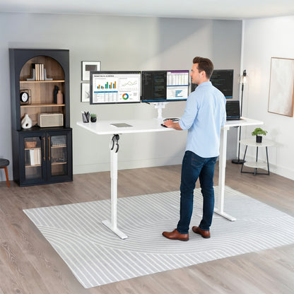 Man standing at the 2E Series - 83" x 30" Electric Desk with Touch Screen Memory Controller in office space