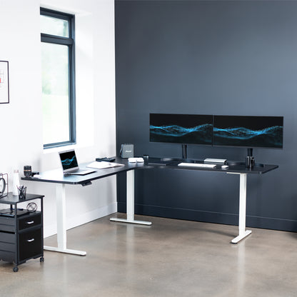 Large heavy-duty electric height adjustable corner desk workstation with programmable memory controller.