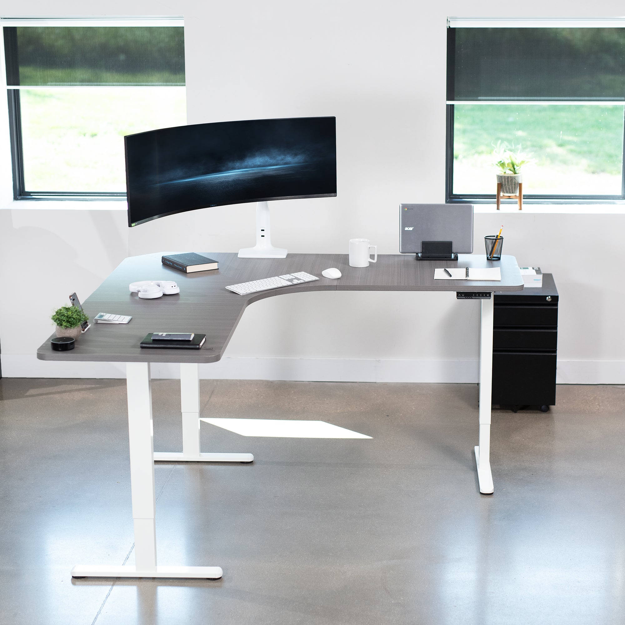 Large heavy-duty electric height adjustable corner desk workstation with programmable memory controller.