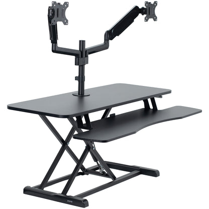 42 inch height adjustable desk riser with articulating pneumatic dual monitor mount.