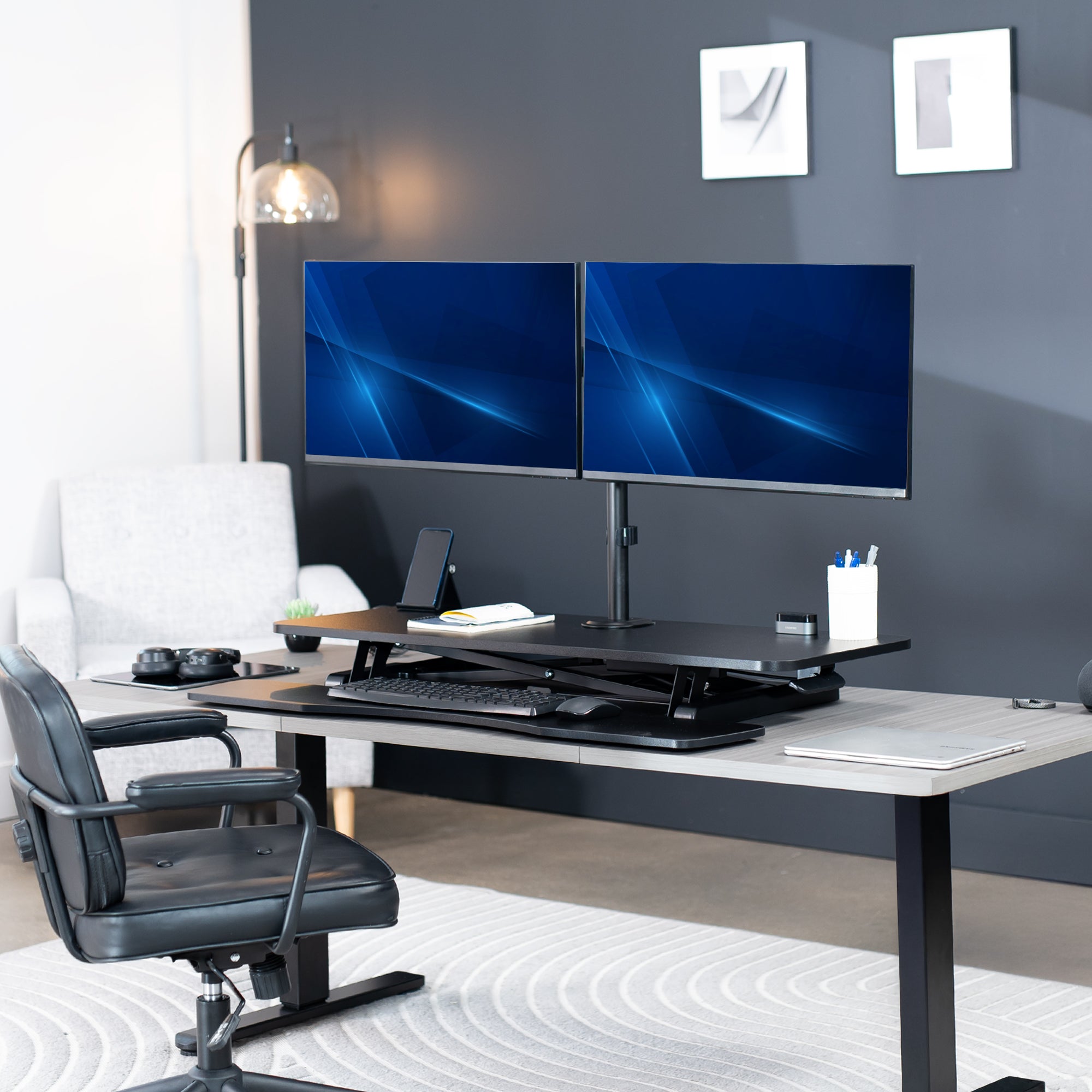 42 inch height adjustable desk riser with articulating mechanical dual monitor mount.