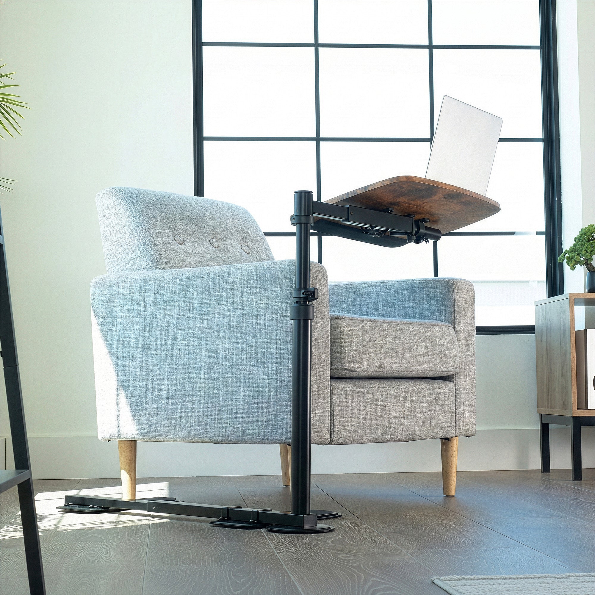 Gray armchair with a adjustable work desk in a modern room.