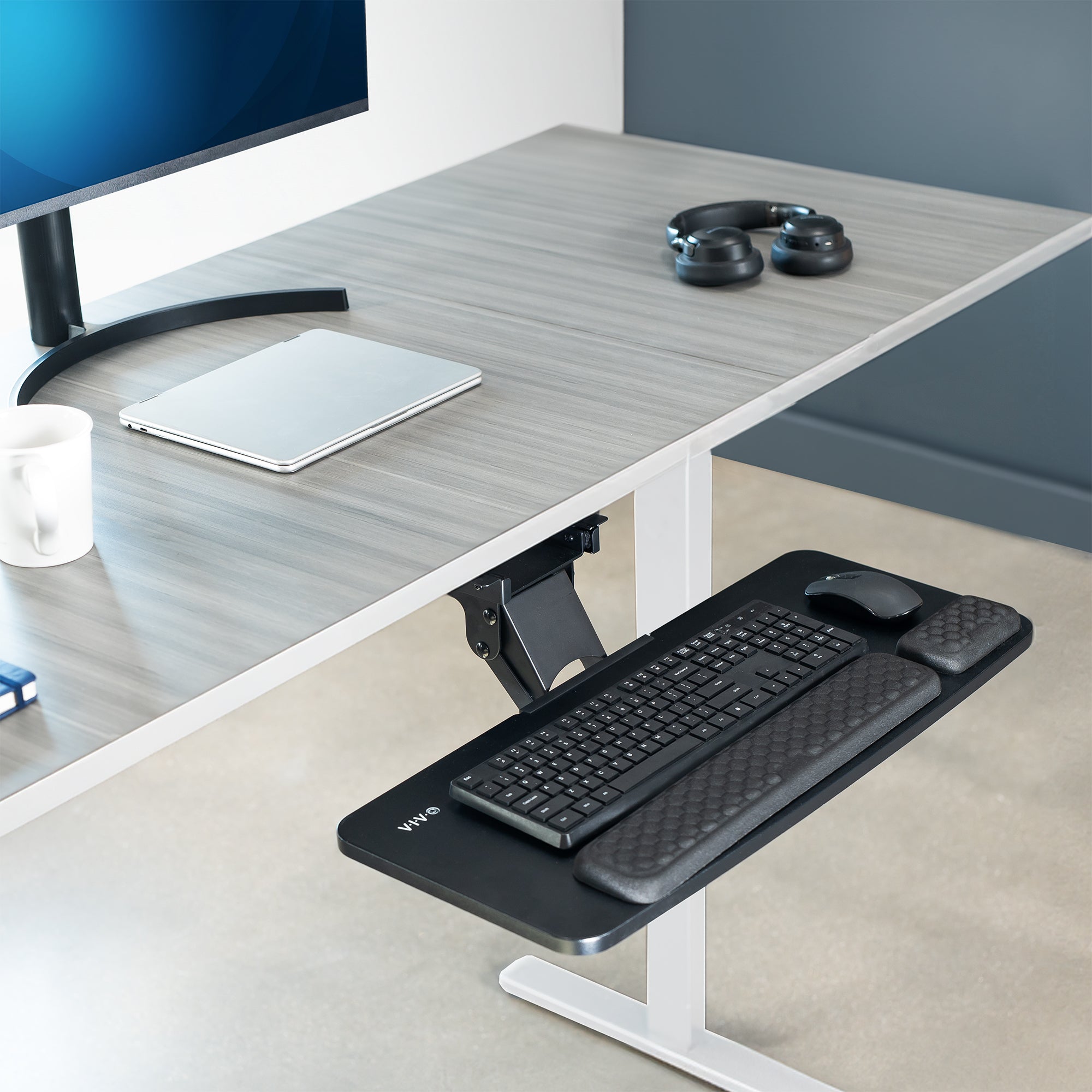 An under desk keyboard tray in a minimalist office. 