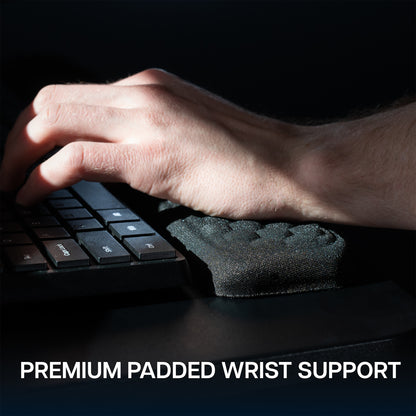 Keyboard tray with a plush wrist pad on a dark background. 
