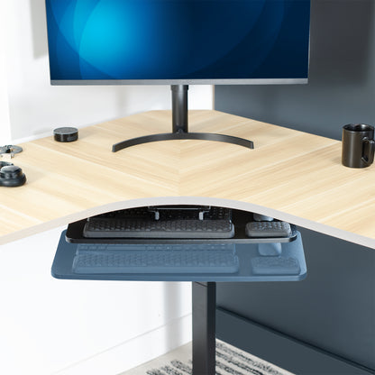 Hideaway under desk keyboard tray under a wooden desk. 