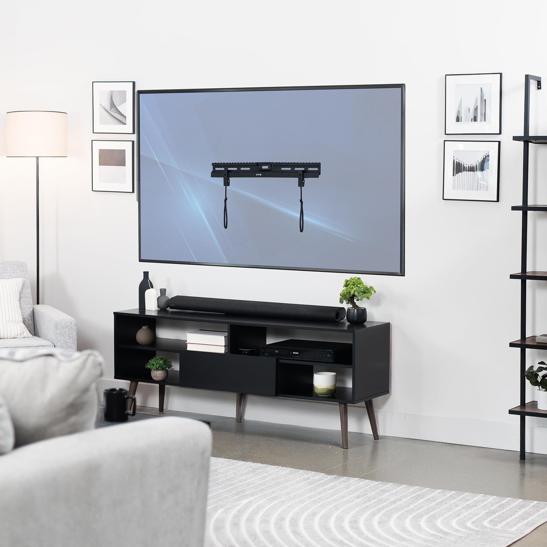 Living room with a TV mounted on the wall above a black entertainment console.