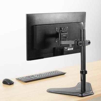 Pole Mount VESA Monitor Arm shown from the back on a light wood desk with a keyboard and mouse against a white background.