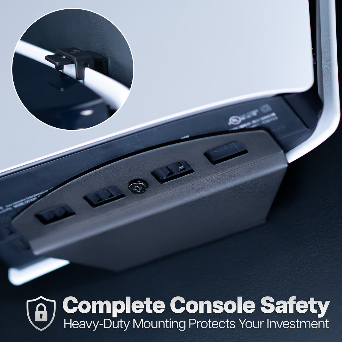 Close-up of a black console safety bracket mounted under a monitor, with a circular inset showing the mounting clip detail and text reading 'Complete Console Safety' at the bottom.