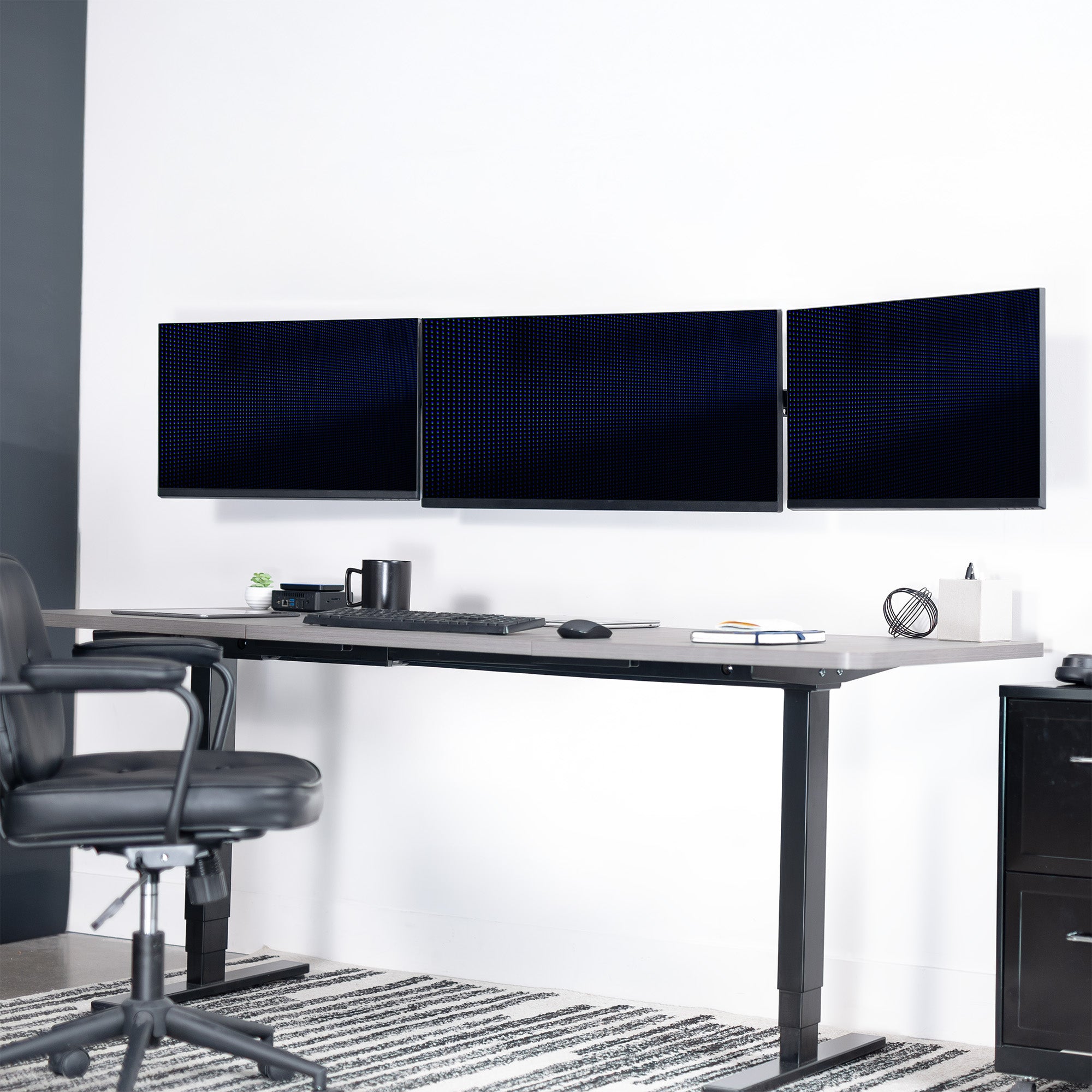 A black telescoping triple monitor wall mount with adjustable arms for mounting multiple screens.