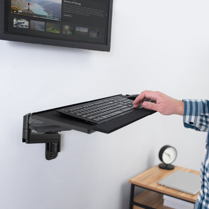 Dual monitor wall mount and height adjustable keyboard tray create a complete wall-mounted workstation.