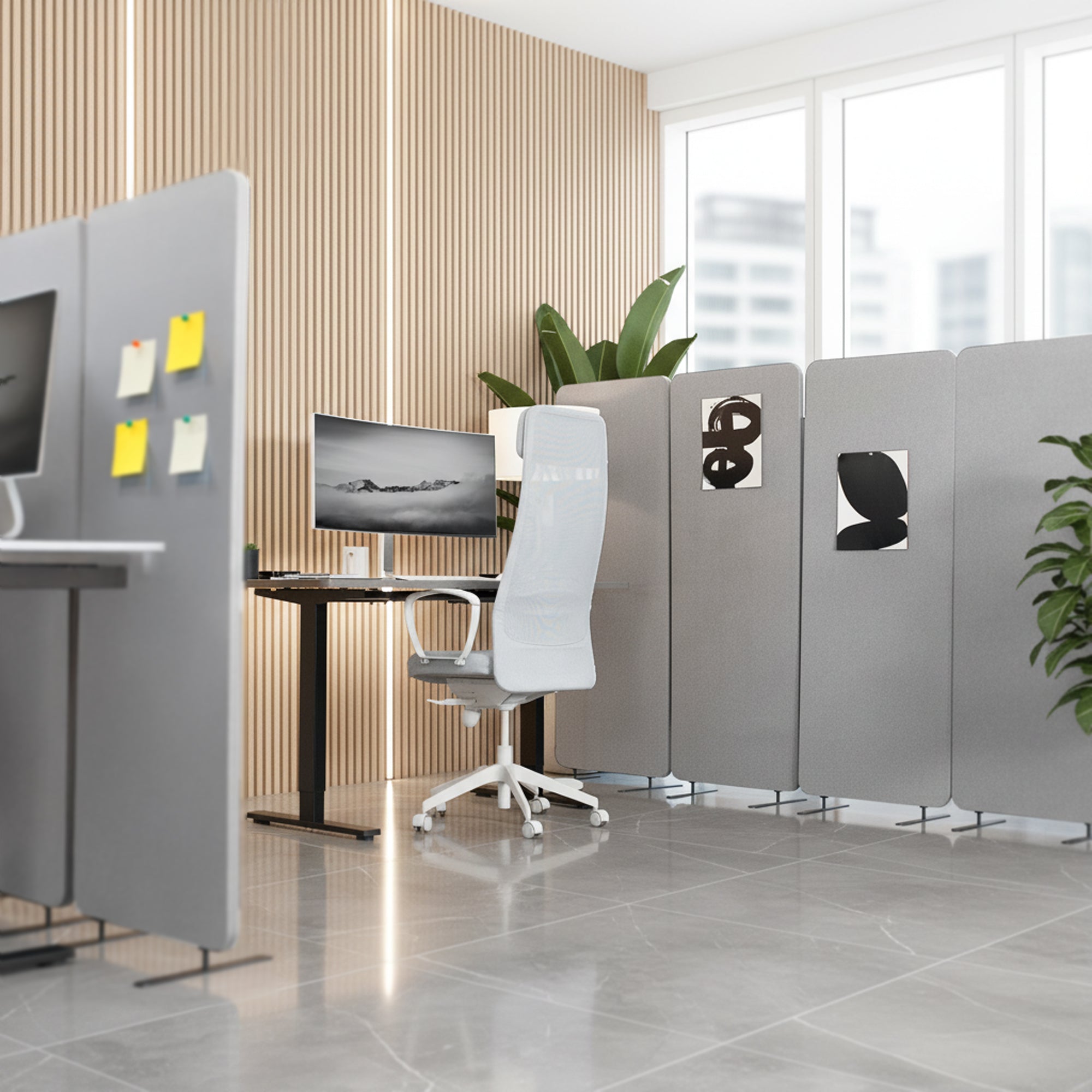 Modern office setup with partitioned workstations, chairs, and computer monitors.