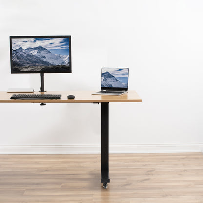 Adjustable height desk with computer setup on a white background