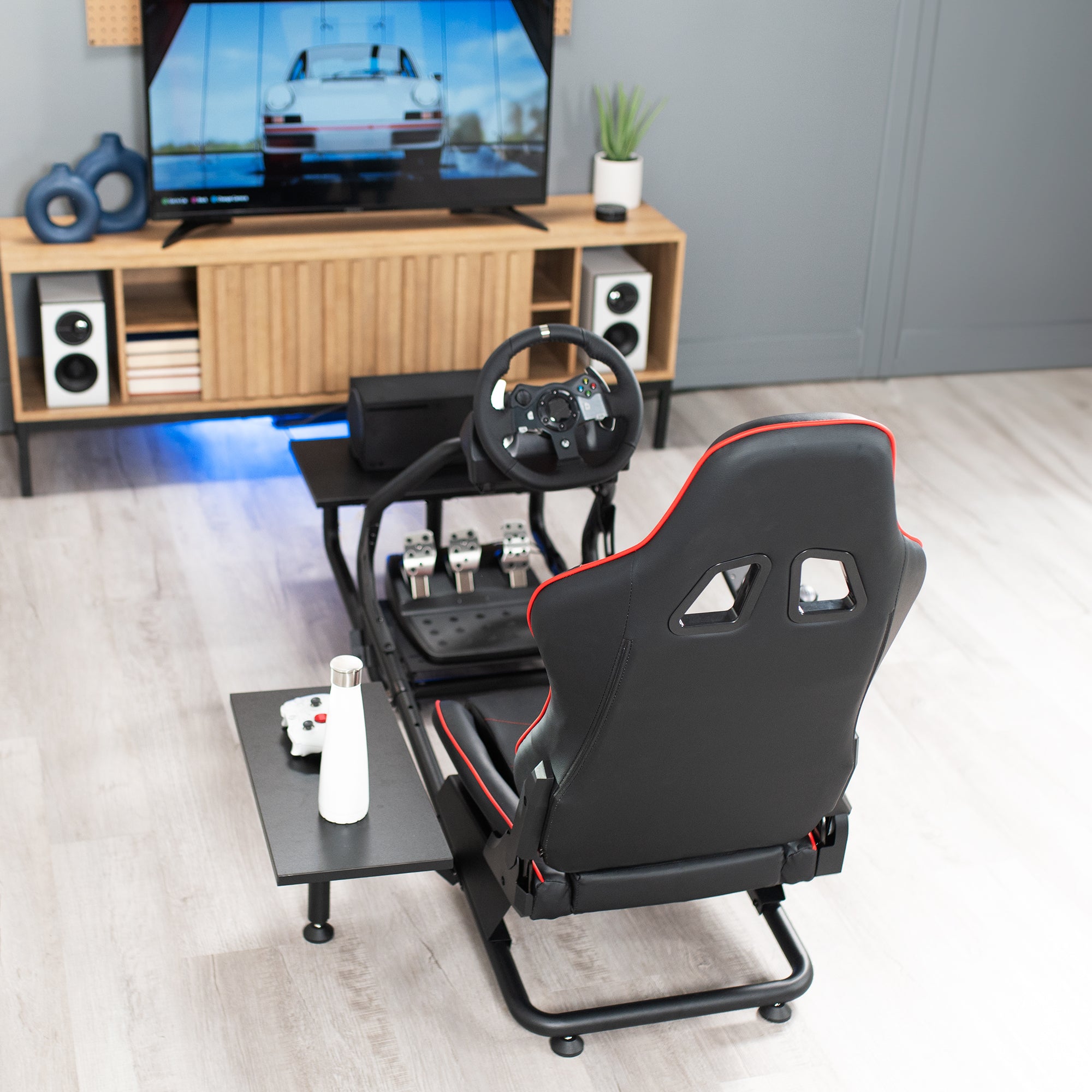 Racing simulator cockpit gaming chair with PC shelf and side shelf.