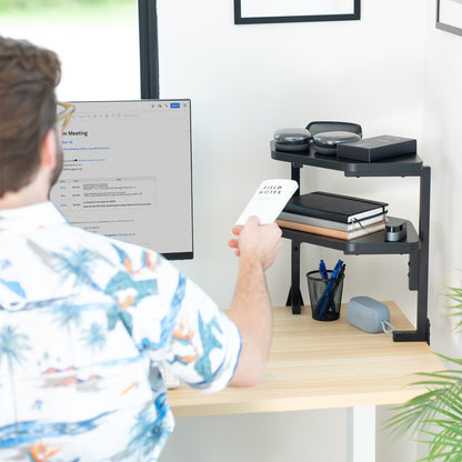 Person sitting at a desk with a computer and desk shelf