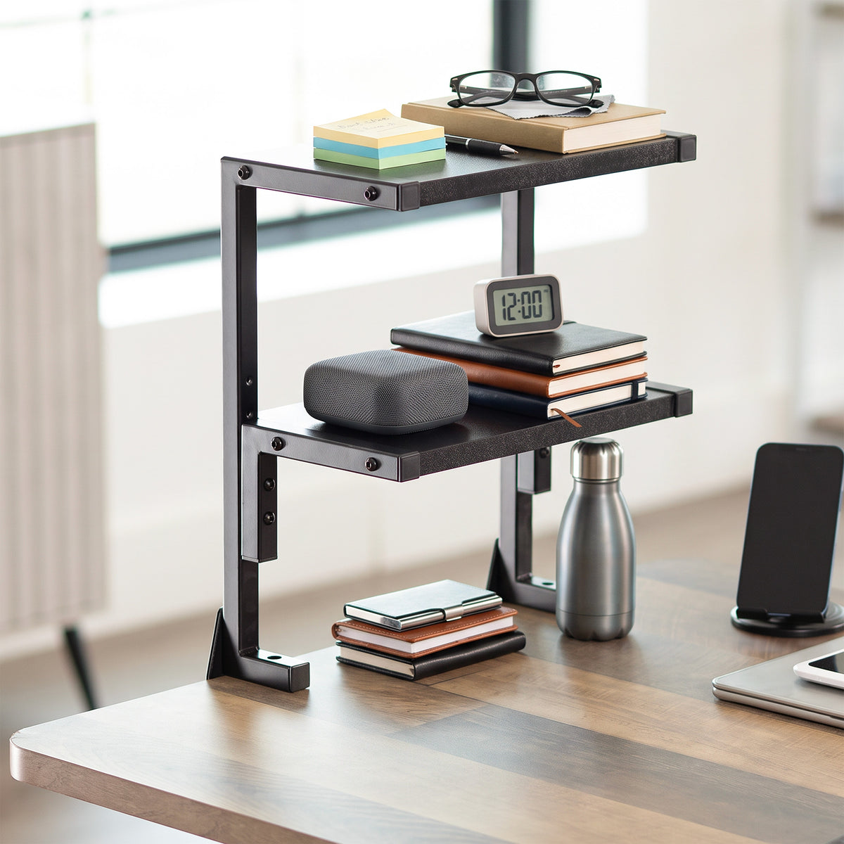 Above/Below Clamp-on Dual Shelf on a desk in a sunny room with desk accessories filling the shelf