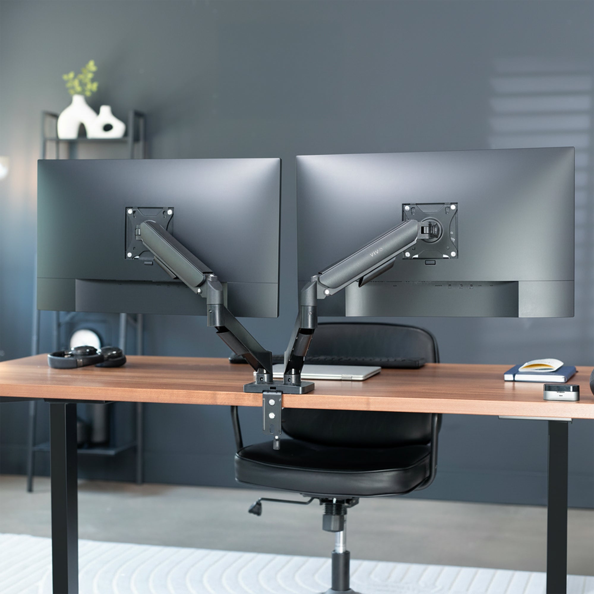 Modern office setup with a wooden desk, ergonomic chair, and dual monitor setup.