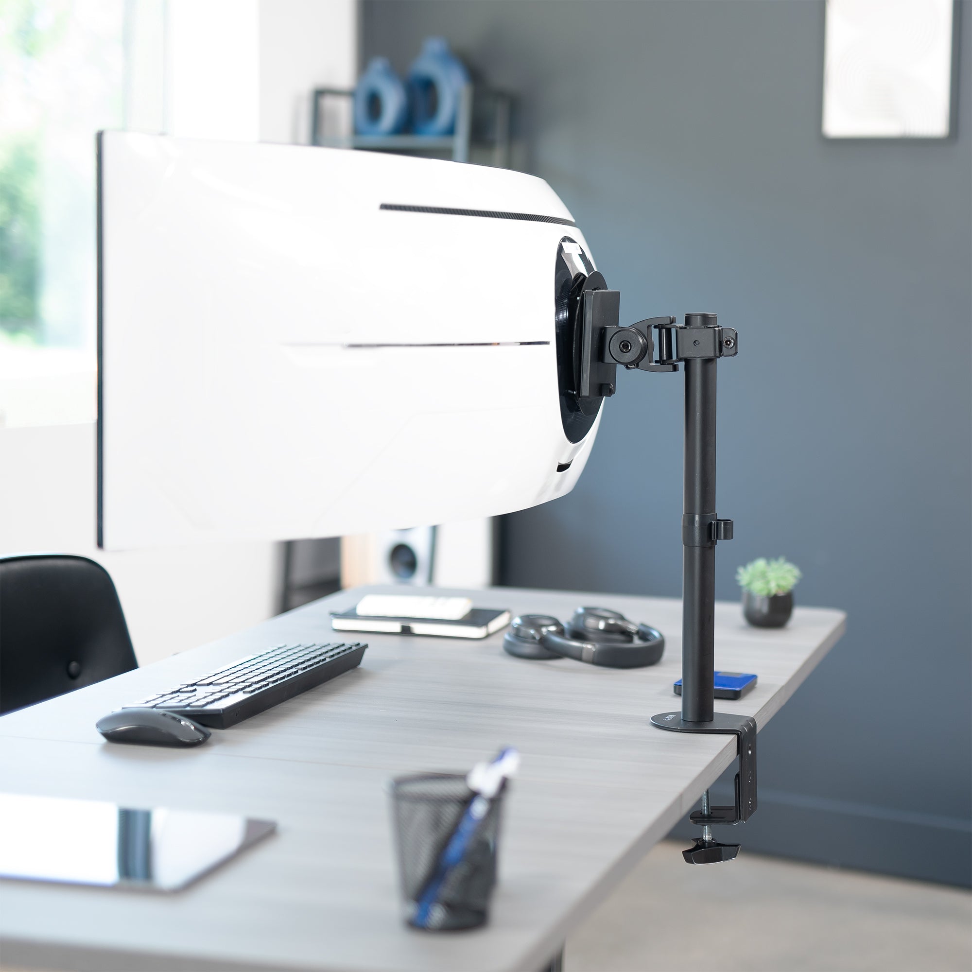 Single ultrawide monitor desk mount in an office setting.