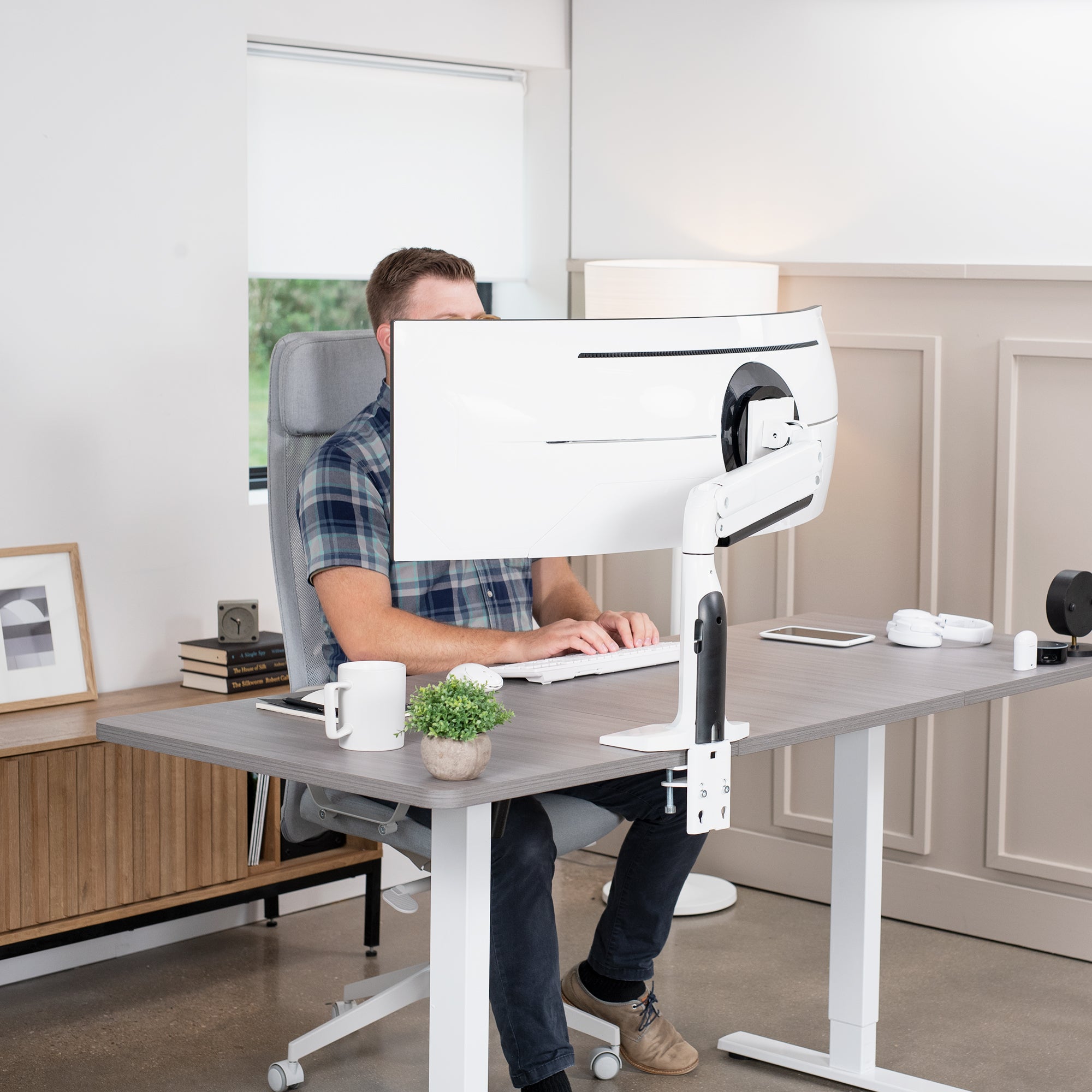 Sturdy height adjustable pneumatic arm supporting a single ultrawide monitor.