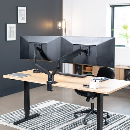 A dual ultrawide monitor desk mount with pneumatic arms in a modern office setting. 