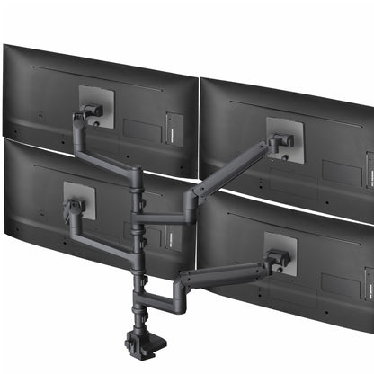 A black pneumatic arm quad ultrawide monitor desk mount with four screens attached to it.