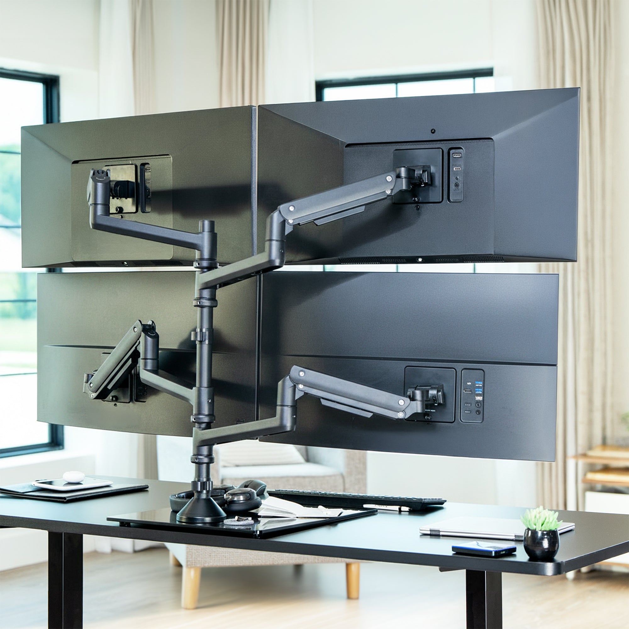 Extra tall freestanding quad monitor mount with four adjustable pneumatic arms supporting a multi-screen desk setup