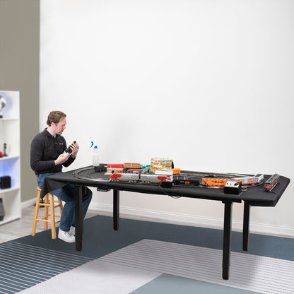 Height adjustable frame for a hobby table, a man working on the set up of a large electric desk.