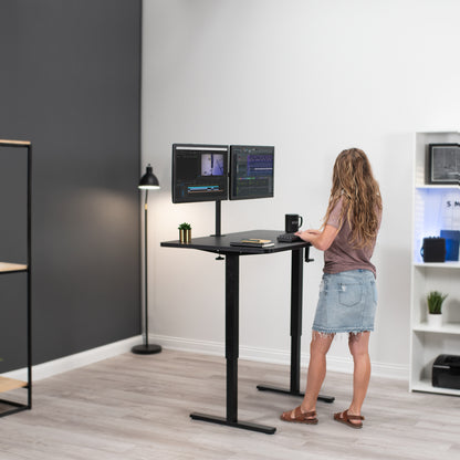 Woman working at a standing height adjustable desk.