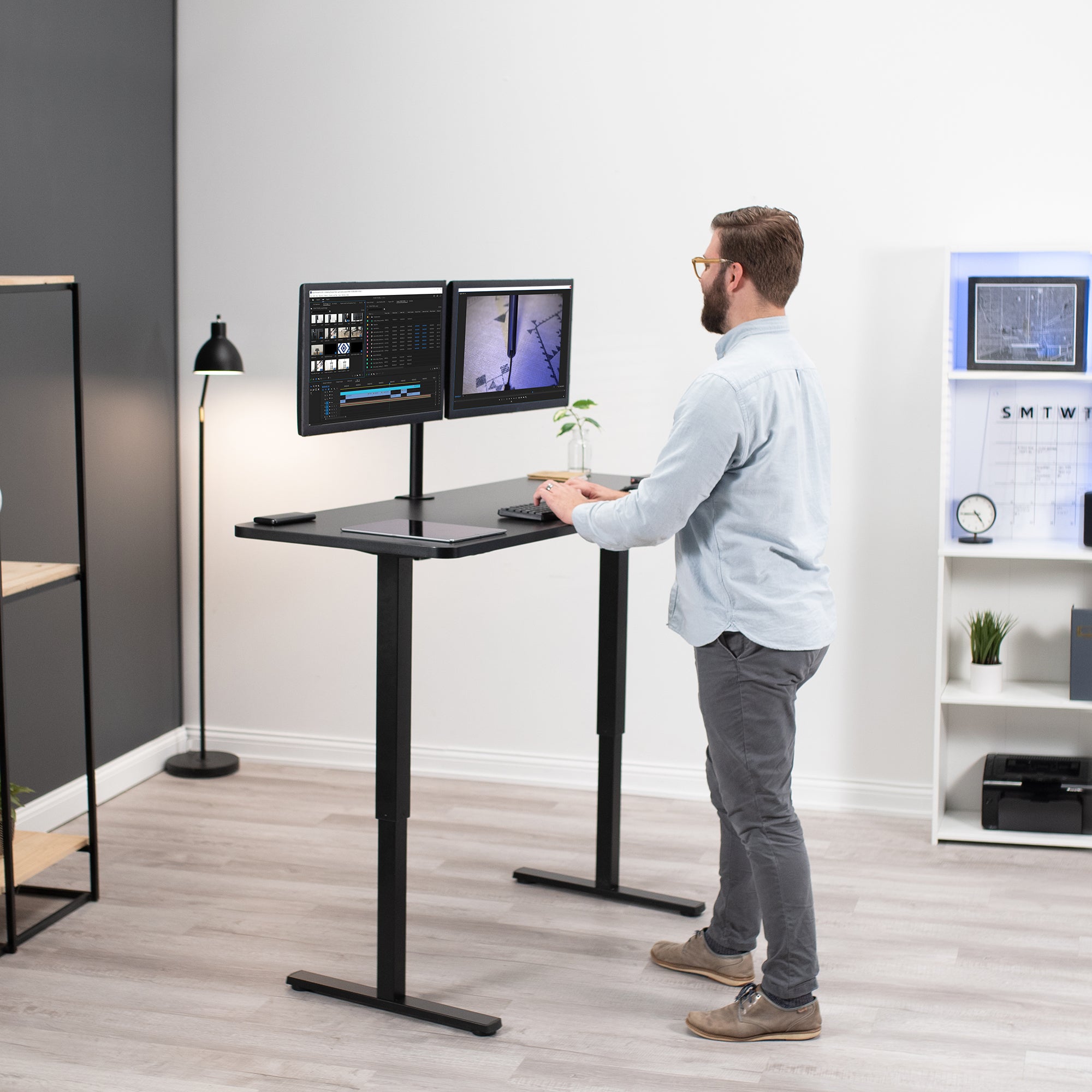 A man working at an ergonomic height-adjustable standing desk.