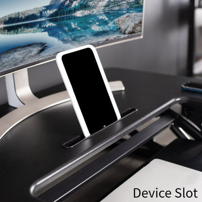 Designated device slot located center front on the top tier of desk riser.