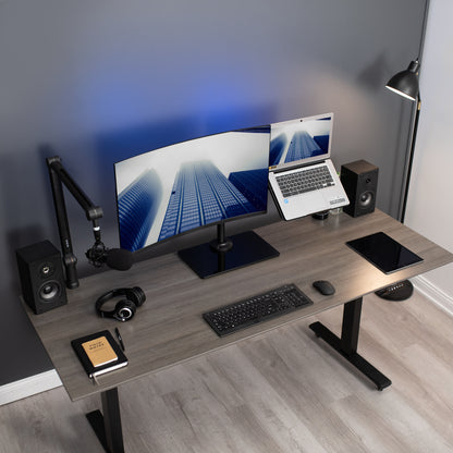 Freestanding monitor and laptop stand with elegant glass base for dual screen viewing and ergonomic placement.